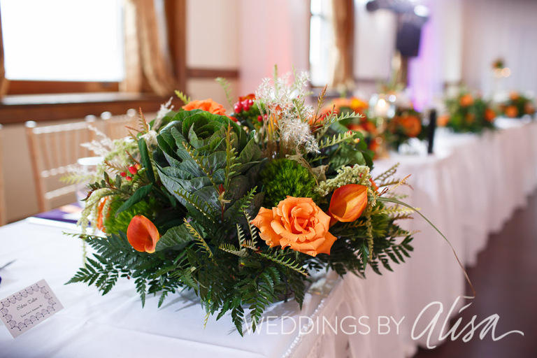 Green cabbage and orange roses at wedding reception