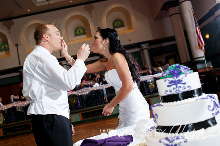 Bride and groom eating cake at their wedding reception at the Syria Mosque