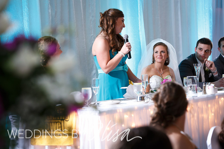 Toasting the bride and groom at wedding reception with turquoise blue up lighting