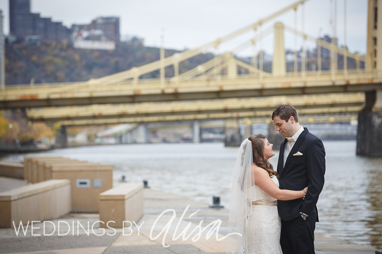 Bride and groom take wedding photos in front of Roberto Clemente Bridge