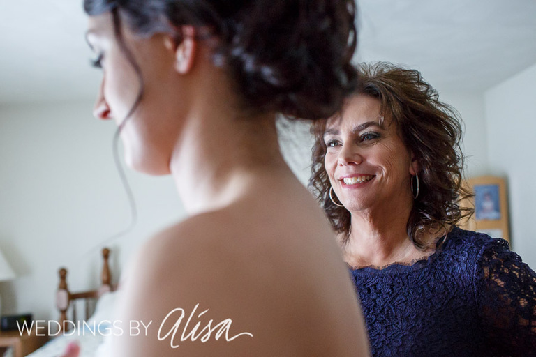 Bride getting dressed with mother
