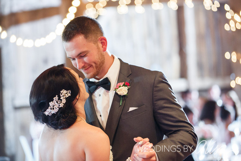 Bride and groom have first dance in barn