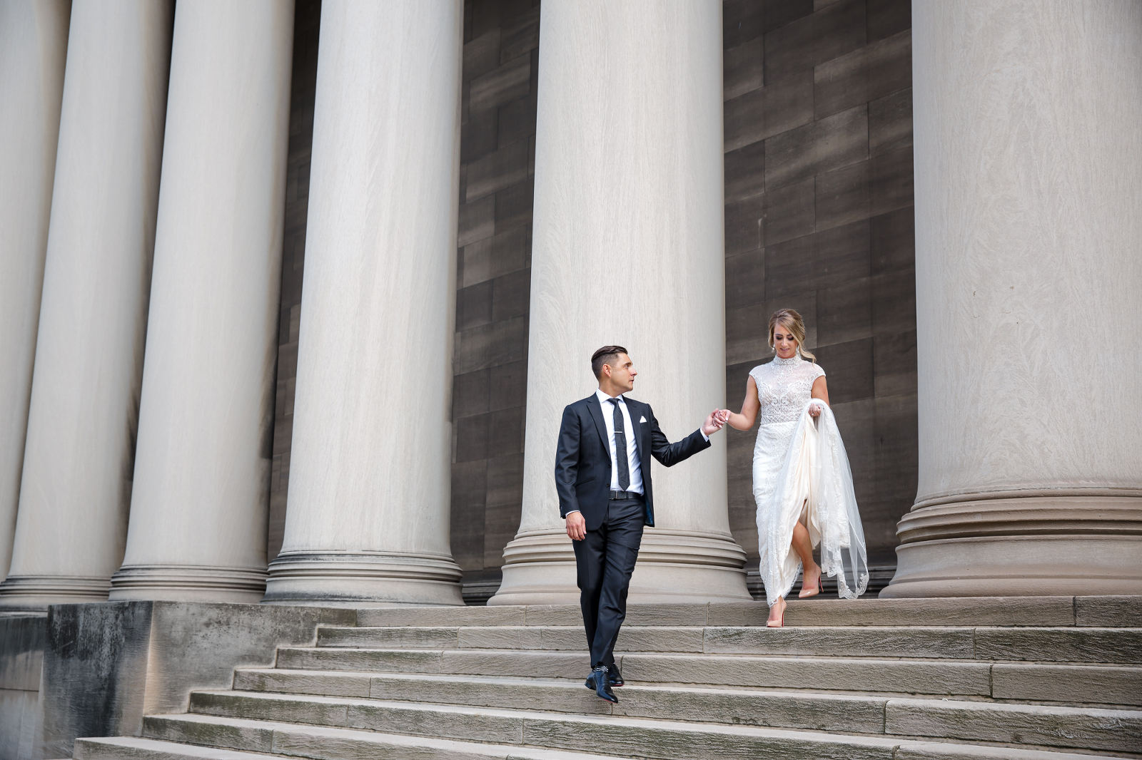 Bride and Groom walking down steps at Mellon Columns