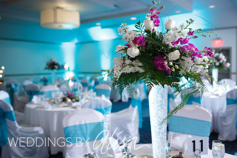 Tall Orchid wedding centerpieces with turquoise chair ribbons